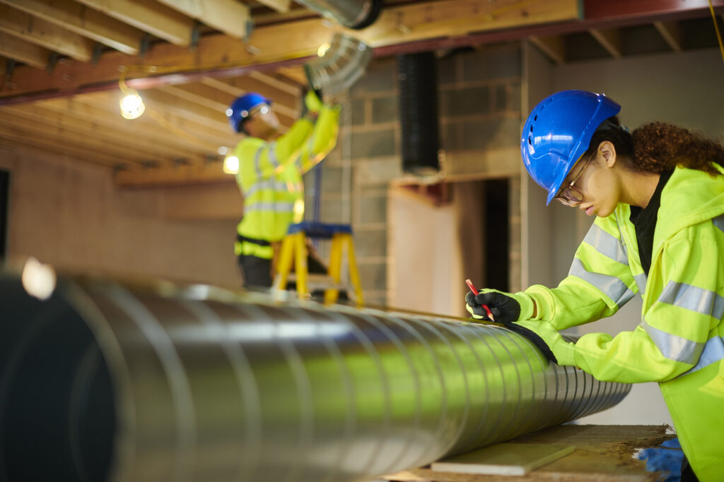HVAC technicians working on a commercial HVAC ventilation system