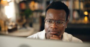 Trade school student in front of computer with glasses on