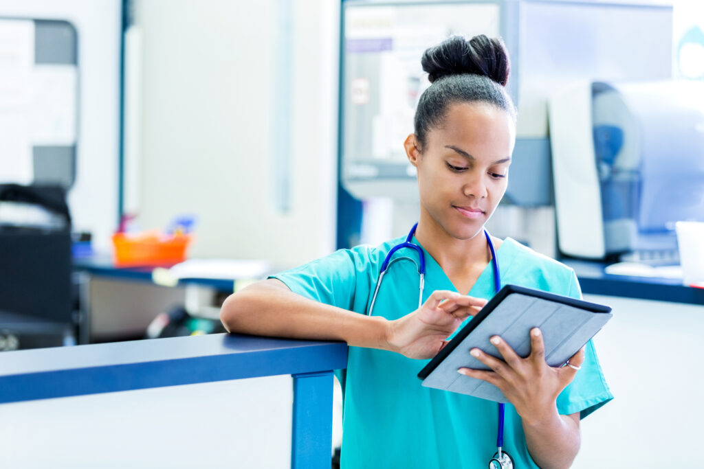 nurse at front desk of a hosptial reading a patient chart